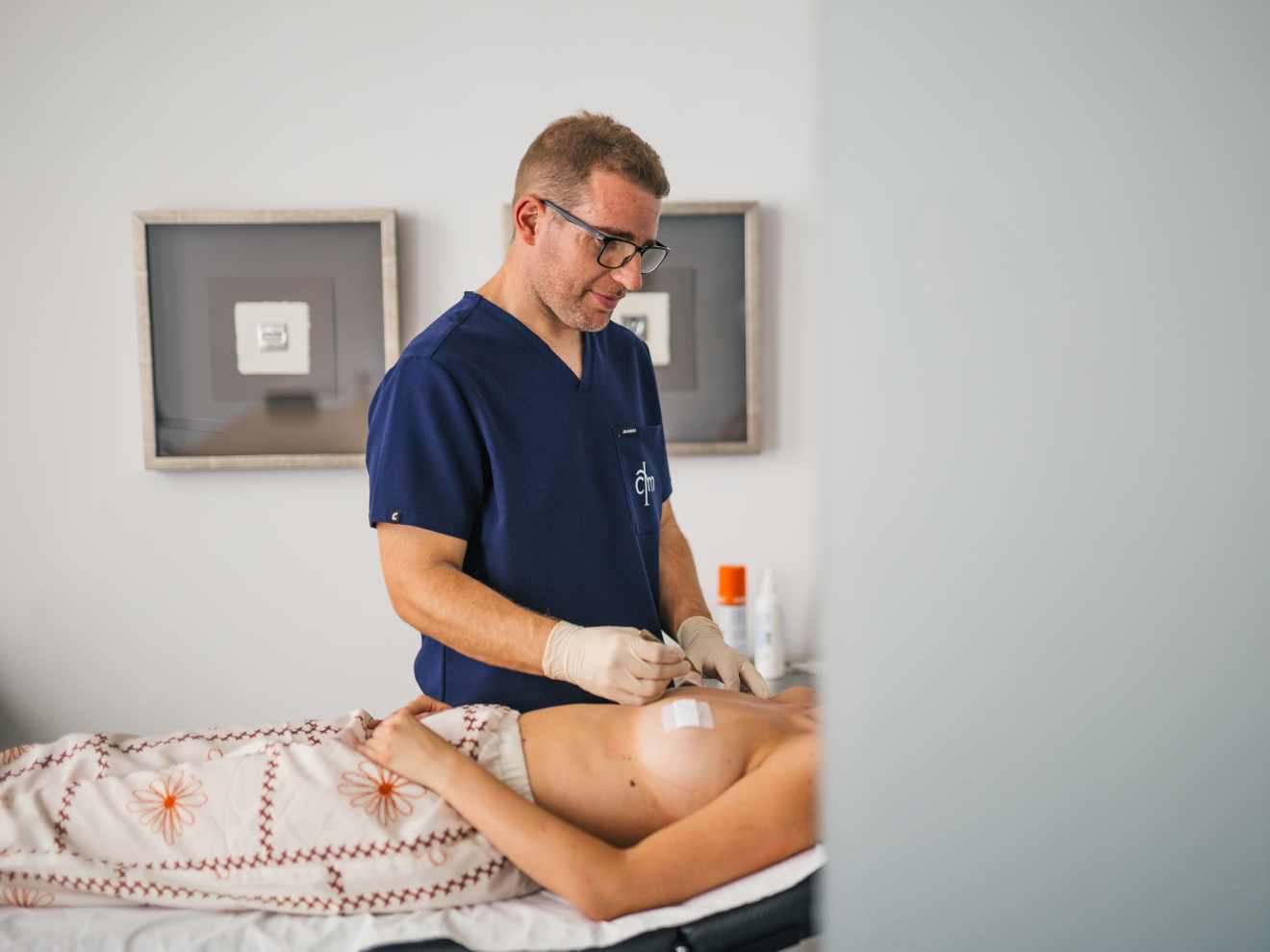 El Dr. Edgar Orquin realiza una cura a una paciente operada de elevacion de pecho